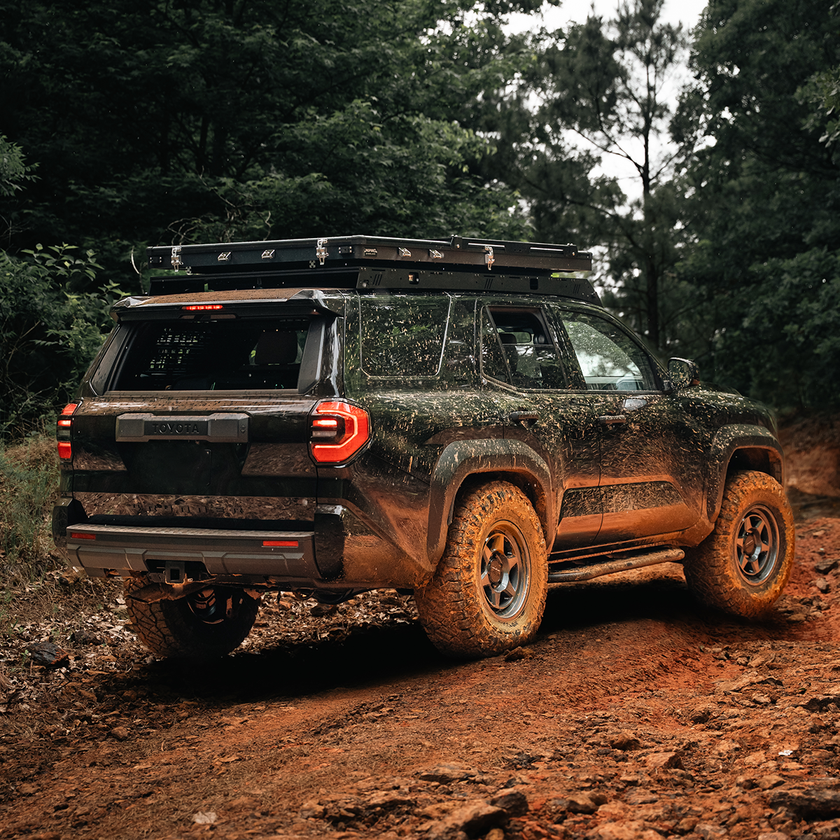 Off-road vehicle on a dirt path with trees in the background